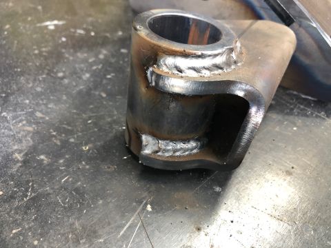 1992 Jeep Wrangler - A metal component with visible welds and a cylindrical opening sits on a workbench.