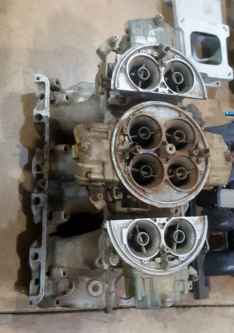 1973 Ford Mustang - A four-barrel carburetor with an attached intake manifold is shown against a neutral background.