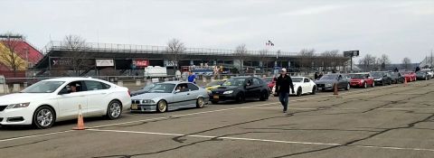 2006 Mitsubishi Evolution - Multiple vehicles lined up on a paved surface, possibly a racetrack, under an overcast sky.