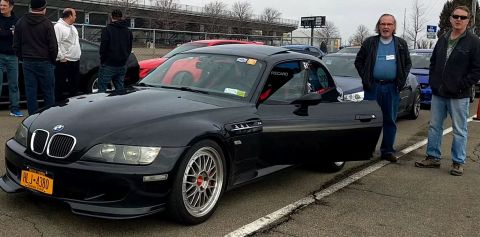 2006 Mitsubishi Evolution - A black BMW Z3 M Coupe is parked at an event with several people around it.
