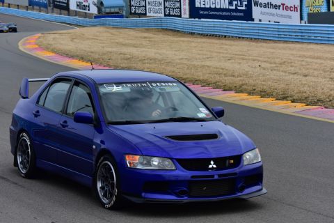 2006 Mitsubishi Evolution - A blue Mitsubishi Lancer Evolution VIII is seen on a race track with a banner on its windshield.