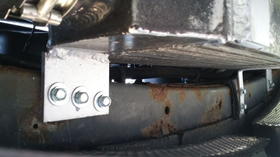 Custom metal brackets bolted to vehicle undercarriage