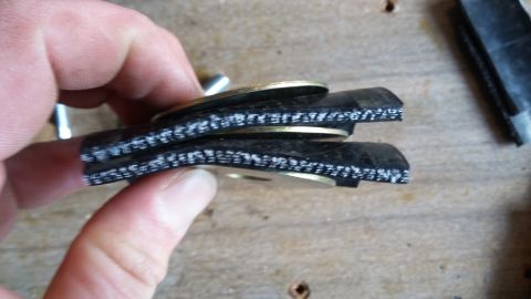 hand holding layered rubber hose with coins between layers