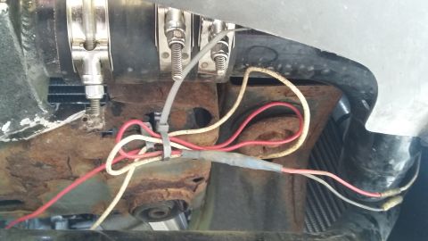 Engine wiring with red and white wires connected to a rusty bracket