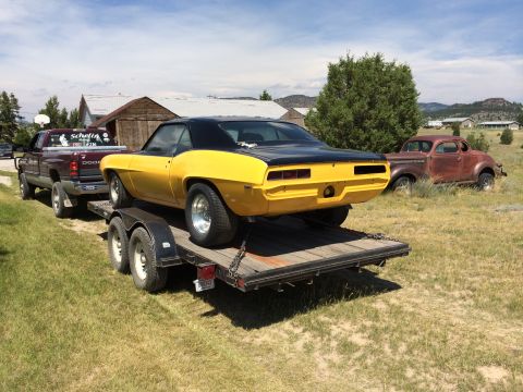 1969 Chevrolet Camaro - 1969 Chevrolet Camaro being transported on a trailer, with a Dodge pickup truck and an older vehicle visible.