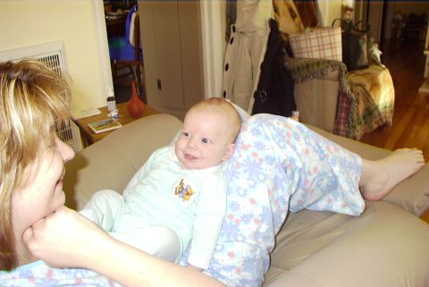 1995 Ford Bronco - A woman interacts with a baby while sitting on a couch in a living room.
