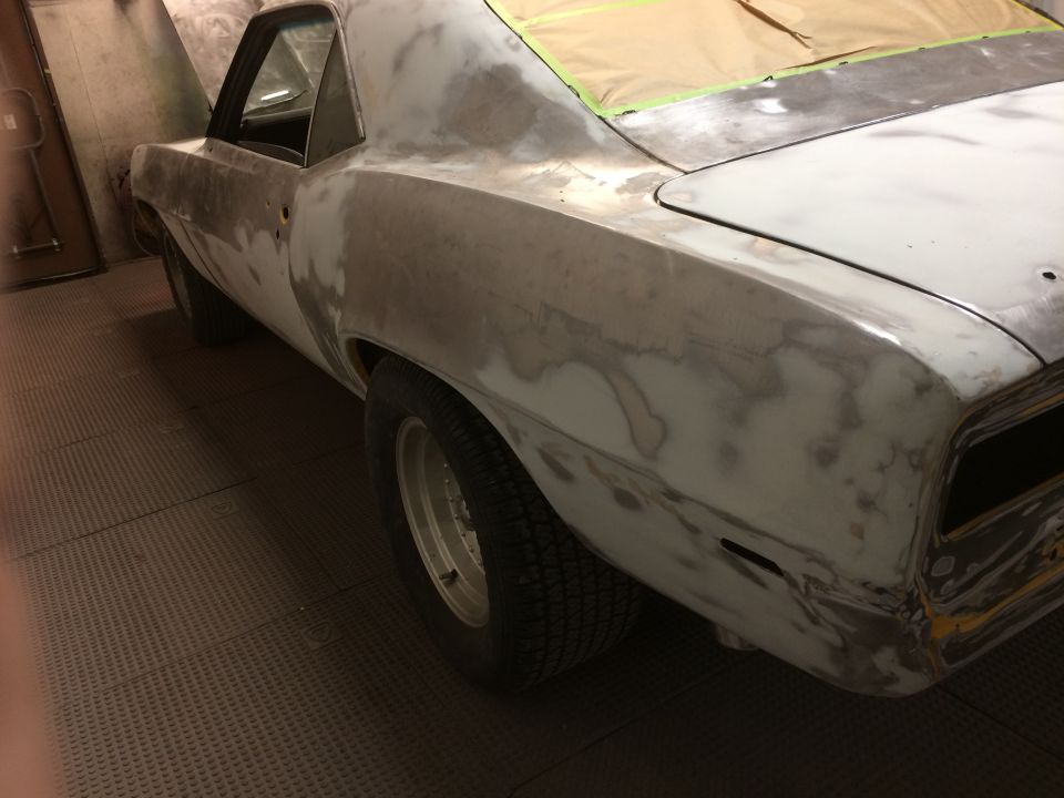 1969 Chevrolet Camaro bodywork in progress, showing primer and masking tape on the rear deck