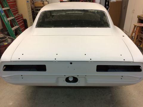 1969 Chevrolet Camaro - This classic car body, primed white, is awaiting restoration in a garage setting.