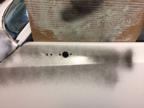 1969 Chevrolet Camaro - A car door panel is shown with holes for hardware, possibly undergoing repair or modification.