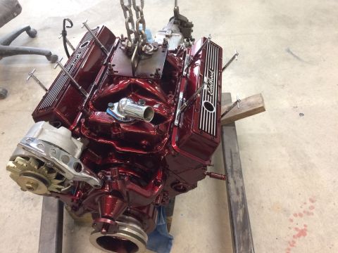 1969 Chevrolet Camaro - Engine with Edelbrock valve covers is suspended by chains, ready for installation.