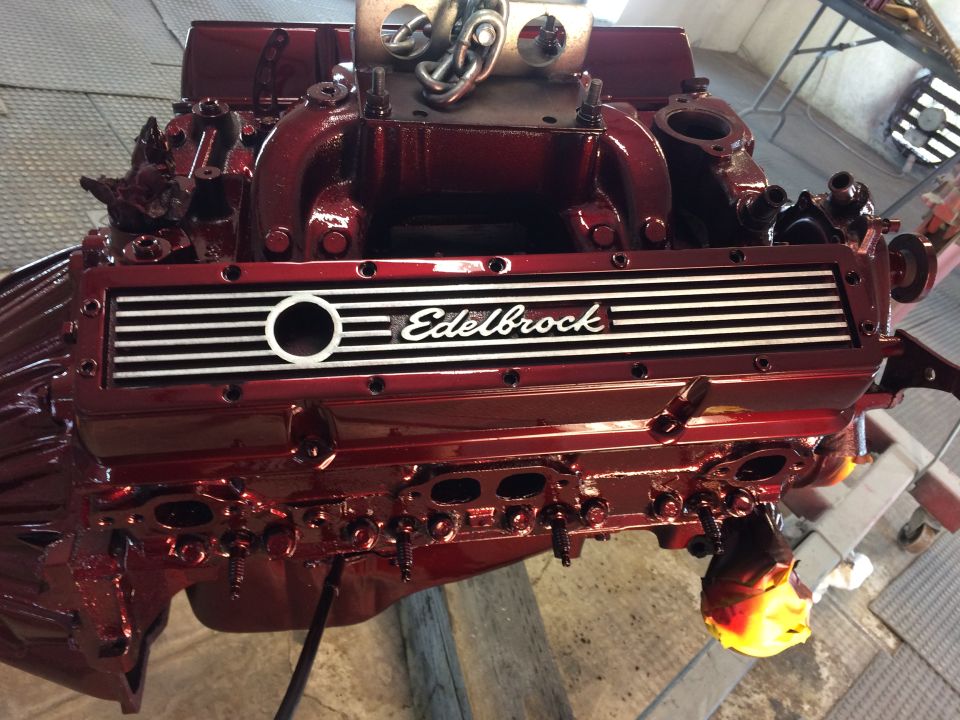 Red Edelbrock intake manifold on a V8 engine block, viewed from the front