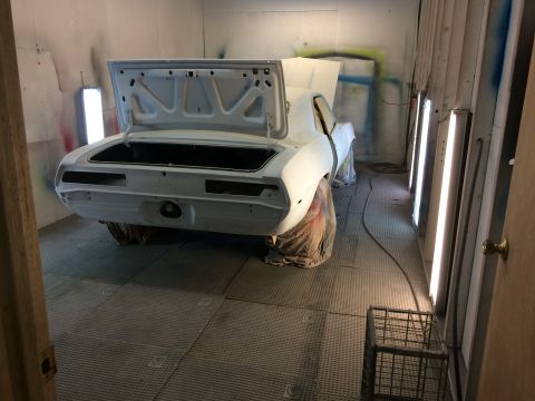 1969 Chevrolet Camaro - A 1969 Chevrolet Camaro is prepped for paint in a booth, showing its rear and open trunk.
