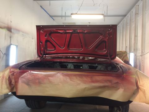 1969 Chevrolet Camaro - The rear of a red 1969 Chevrolet Camaro is shown with the trunk open, inside a paint booth.