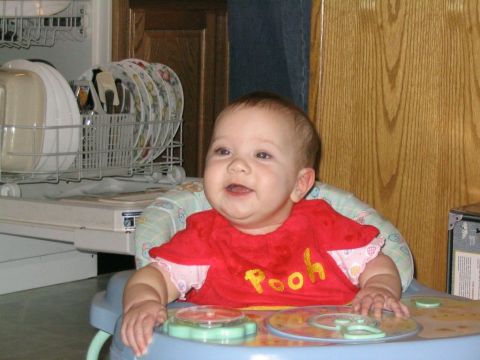 2004 Ford Taurus - A baby sits in a walker, wearing a Pooh shirt, with a dishwasher in the background.