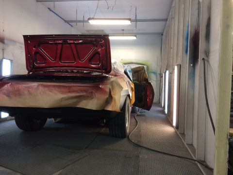 1969 Chevrolet Camaro - Car undergoing paint work inside a professional spray booth, with the trunk lid open.