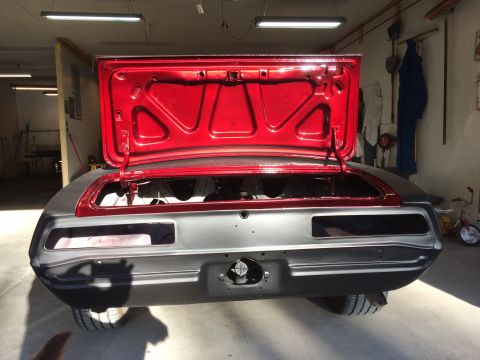 1969 Chevrolet Camaro - The rear of a classic car, possibly a 1969 Chevrolet Camaro, is shown with its trunk open in a workshop setting.