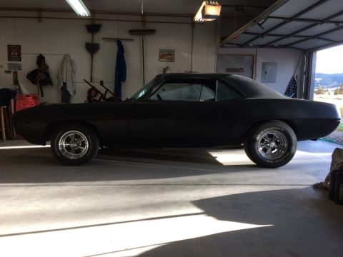 1969 Chevrolet Camaro - A matte black 1969 Chevrolet Camaro coupe sits in a garage, showing its classic lines.