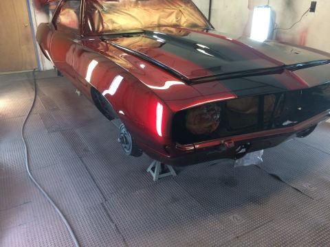 1969 Chevrolet Camaro - A classic 1969 Chevrolet Camaro is shown in a paint booth, undergoing restoration with a fresh coat of paint.