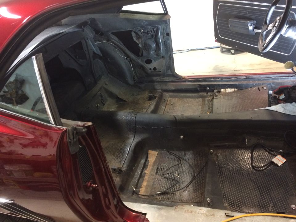 1969 Chevrolet Camaro interior stripped down for restoration, showing bare floor and door panels