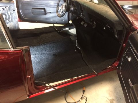 1969 Chevrolet Camaro - The interior of a classic car shows newly installed black carpeting covering the floor.