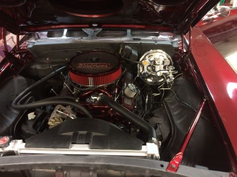 1969 Chevrolet Camaro - The engine bay of a red 1969 Chevrolet Camaro shows a polished engine with a chrome air cleaner and brake booster.