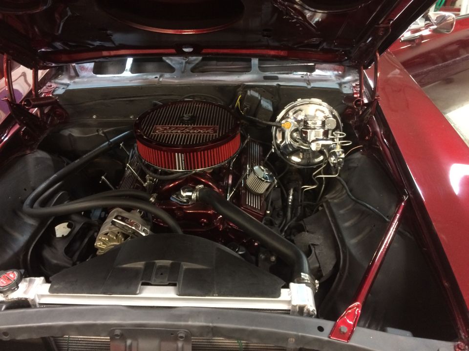 Red 1969 Chevrolet Camaro engine bay with chrome air cleaner and brake booster