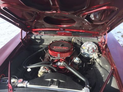 1969 Chevrolet Camaro - The engine bay of a 1969 Chevrolet Camaro, a prominent red air filter and polished chrome parts under the open hood.
