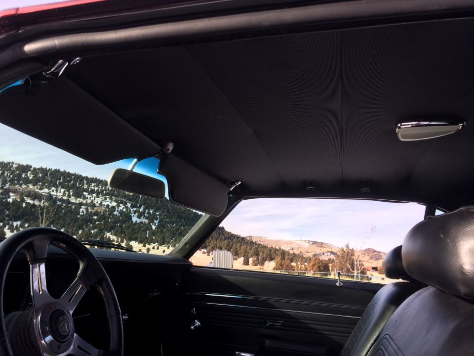 Interior of a 1969 Chevrolet Camaro showing black seats, sun visors, and steering wheel