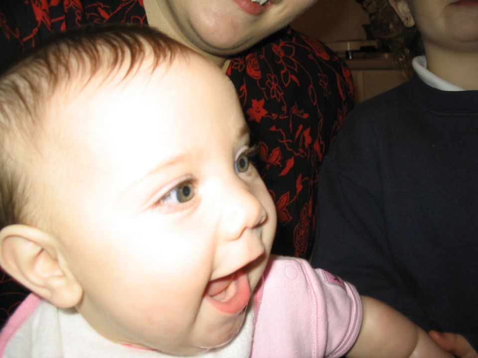 baby smiling, with two adults behind. Supermotors logo in corner