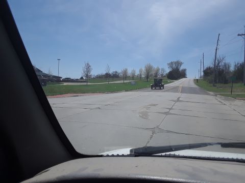 1994 Ford Bronco - An old-fashioned car drives away on a sunny day.