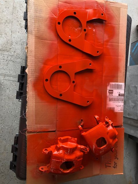 1992 Jeep Wrangler - Painted brake calipers and mounting brackets are laid out on cardboard, ready for installation.