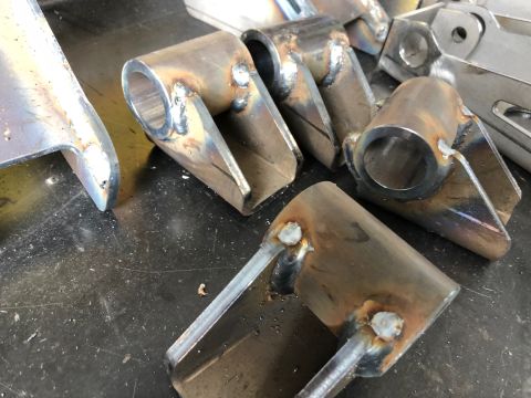 1992 Jeep Wrangler - Group of custom-fabricated metal brackets, likely for automotive use, shown on a work surface.