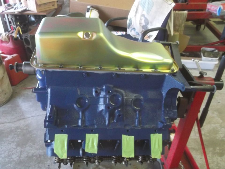 Blue engine block with gold oil pan on an engine stand