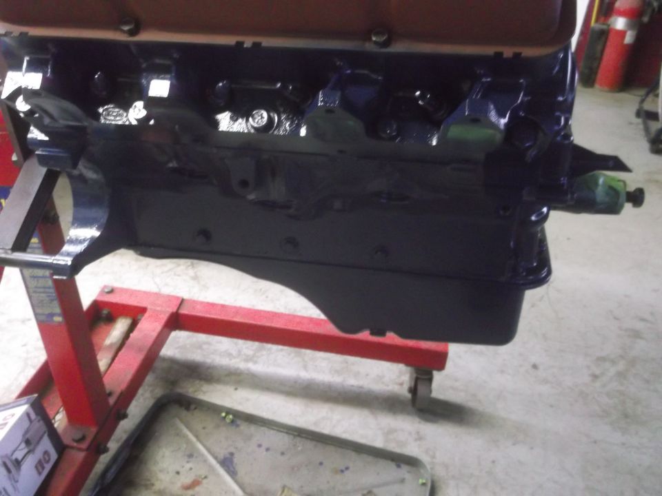Black engine block on a red engine stand, with a metal oil pan visible