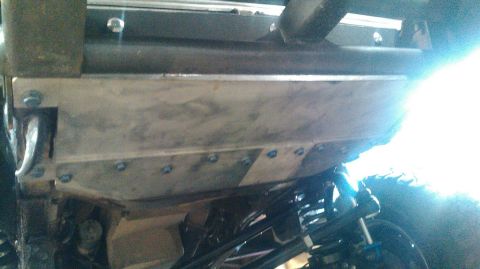 1978 Ford Bronco - Close-up view of a vehicle's underbody, highlighting a skid plate and suspension system.