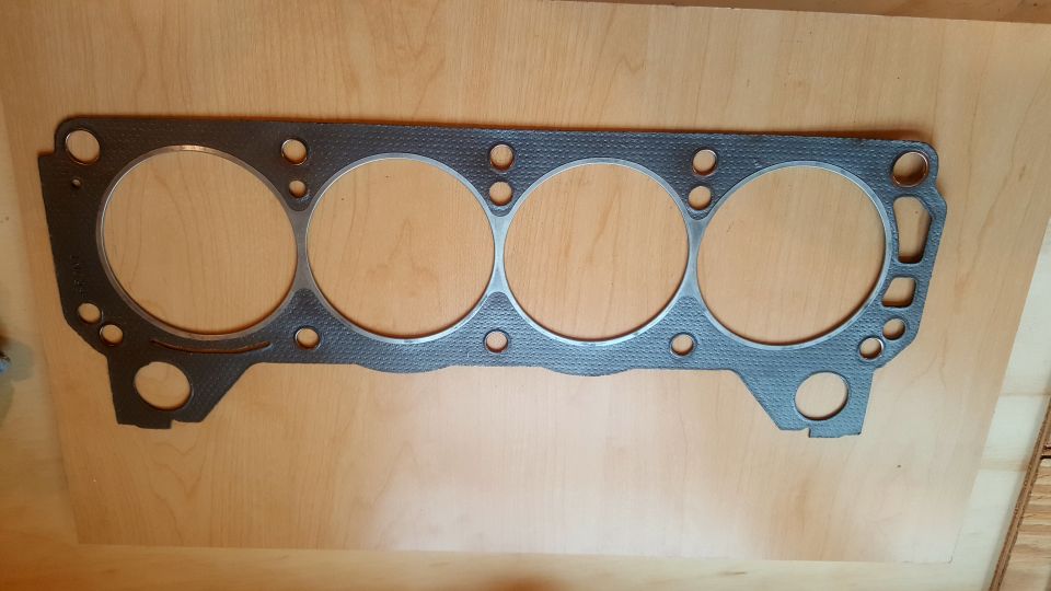 Engine gasket with four large cylinder openings and multiple bolt holes