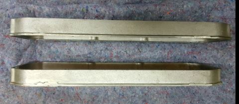 1973 Ford Mustang - Two silver metal valve covers are shown from a side angle on a textured gray surface with a website logo visible.