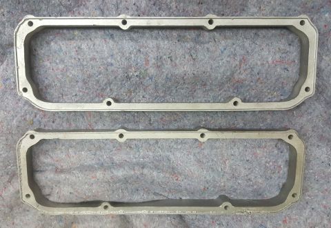 1973 Ford Mustang - Two aluminum valve cover gaskets are shown laid out on a gray textured background.