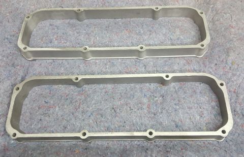 1973 Ford Mustang - Two silver aluminum valve covers are shown from a top-down perspective on a gray textured surface.