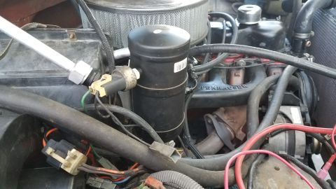 1985 Ford Bronco - Close-up of engine bay components, including AC parts and wiring. Pennzoil text visible.