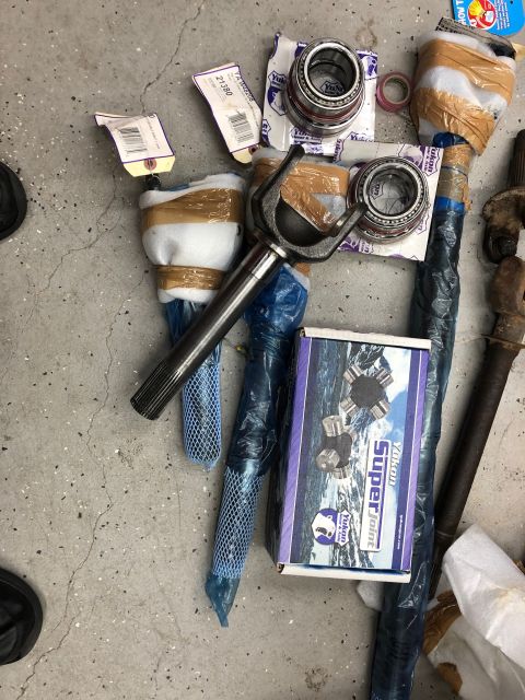 1992 Jeep Wrangler - Yukon Super Joint box and other drivetrain parts laid out on a concrete surface.