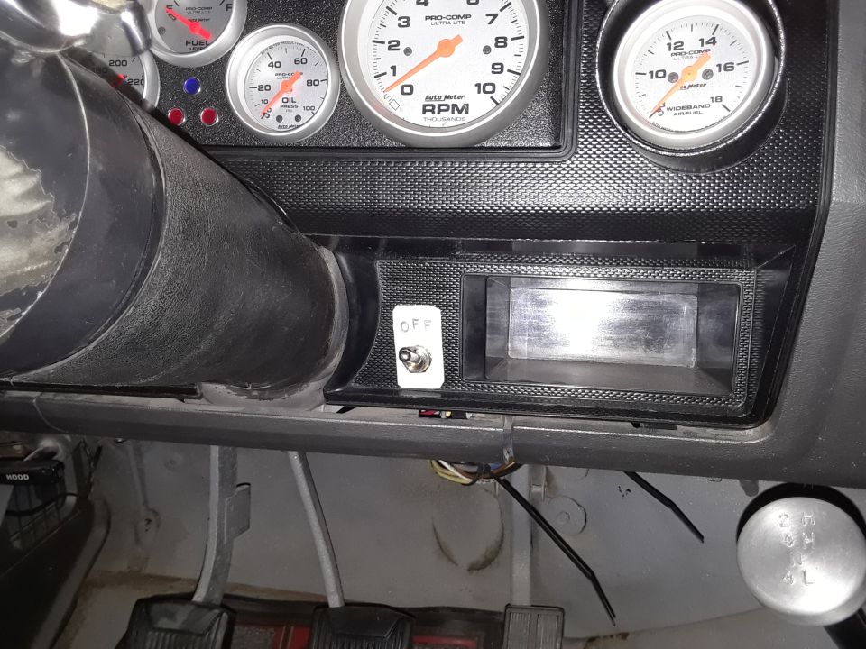 Dashboard with multiple gauges, including RPM and oil pressure, a steering column, and a toggle switch labeled 'OFF'