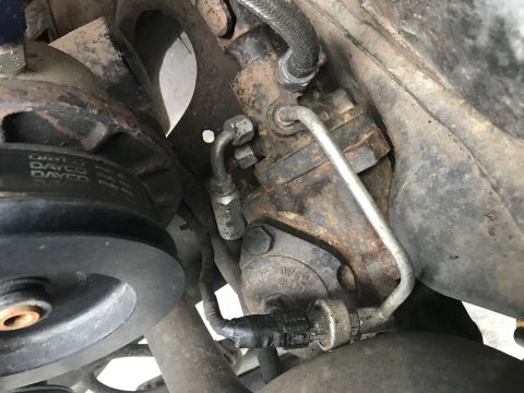 1989 Ford Bronco - Close-up view of the power steering pump and associated plumbing on a vehicle.