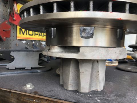 1992 Jeep Wrangler - Close-up of a brake rotor and hub assembly, with a Mopar sign visible in the background.