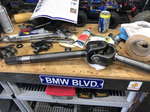 1992 Jeep Wrangler - A workbench is cluttered with tools, a driveshaft, and a can of beer, suggesting a repair or project.