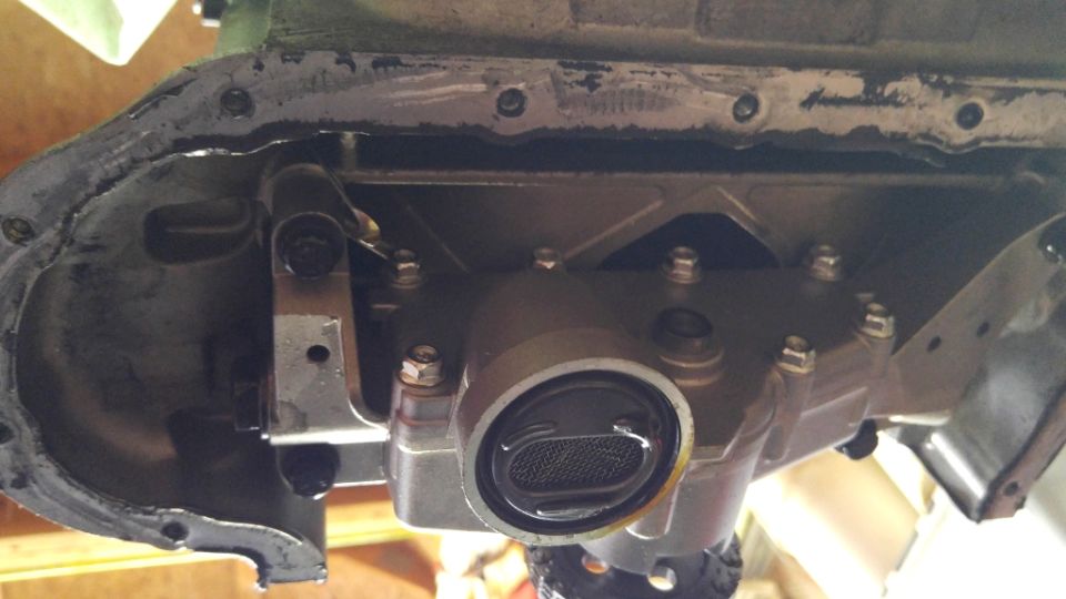 Engine oil pan removed, showing the pickup tube and internal components