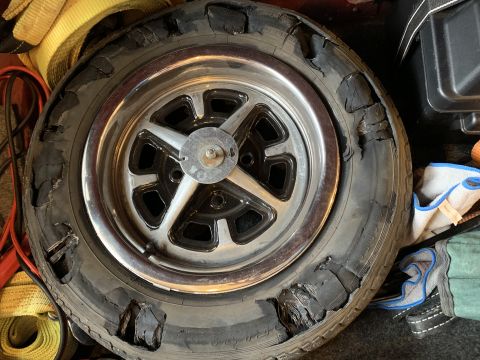 1979 Ford Bronco - A severely damaged tire and wheel are shown, with the tire's sidewall ripped open in multiple places.