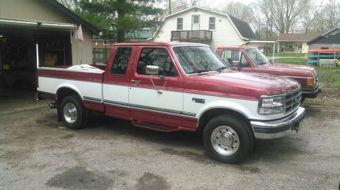 1996 Ford F-250 - Two Ford F-Series trucks are parked in a driveway next to a garage.