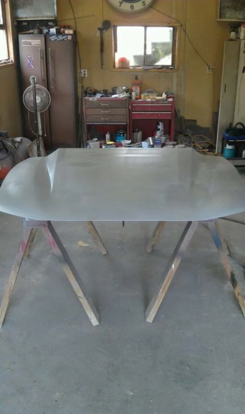 Car hood on sawhorses in a workshop