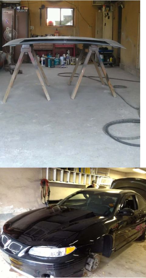 Black 2000 Pontiac Grand Prix coupe with hood open, viewed from front-right in a garage